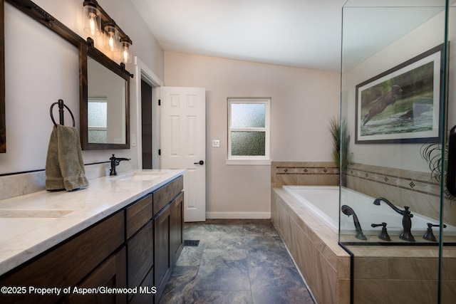 bathroom featuring baseboards, double vanity, and a bath
