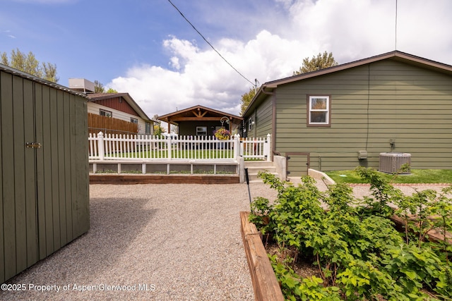 view of property exterior featuring fence and central AC