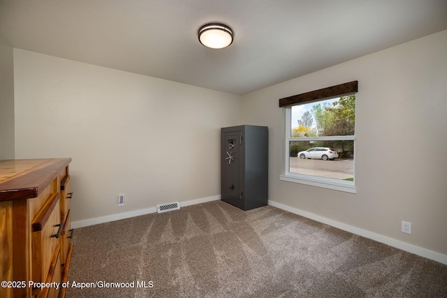 carpeted empty room featuring baseboards