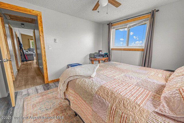 110 Western Ave, Craig, CO 81625 - bedroom with wood finished floors, a textured ceiling, and a ceiling fan