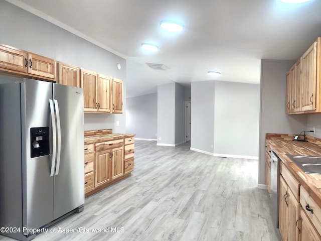 kitchen featuring light brown cabinets, light wood-type flooring, stainless steel appliances, and butcher block counters