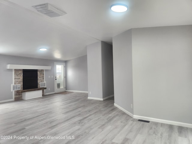 unfurnished living room featuring a fireplace and light hardwood / wood-style floors