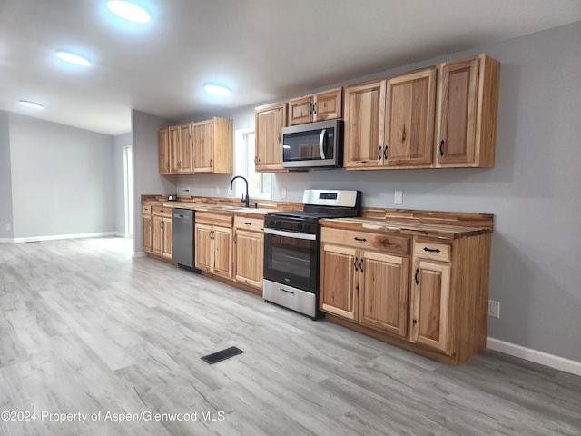 kitchen featuring sink, light wood-type flooring, and stainless steel appliances