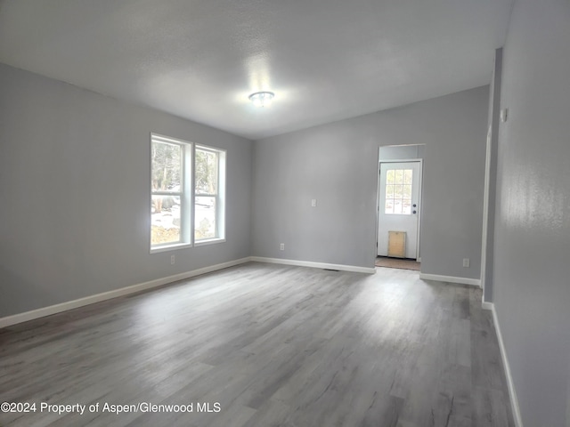 empty room with hardwood / wood-style floors and a wealth of natural light