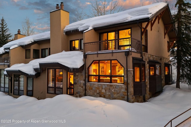 snow covered property featuring a balcony