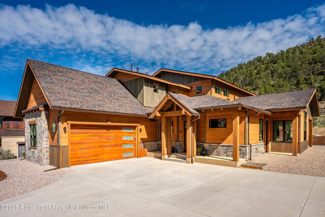 129 Sage Meadow Rd, Glenwood Springs, CO 81601 - view of front facade featuring concrete driveway, a porch, stone siding, and a garage