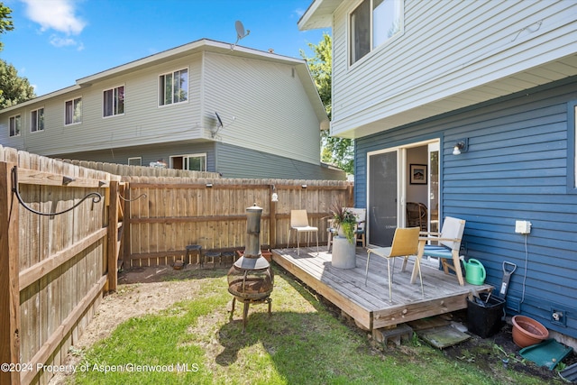 view of yard featuring a deck and an outdoor fire pit