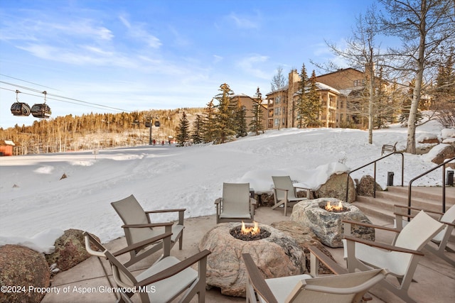 yard covered in snow featuring an outdoor fire pit