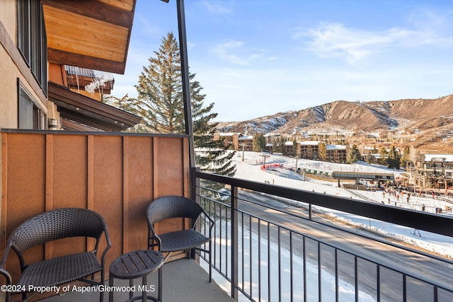 snow covered back of property featuring a mountain view