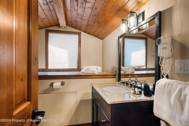 bathroom with vaulted ceiling with beams, vanity, and wood ceiling