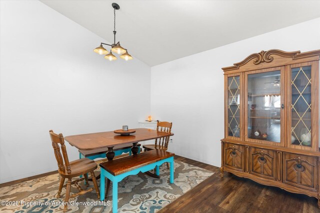 dining space with vaulted ceiling and dark hardwood / wood-style floors