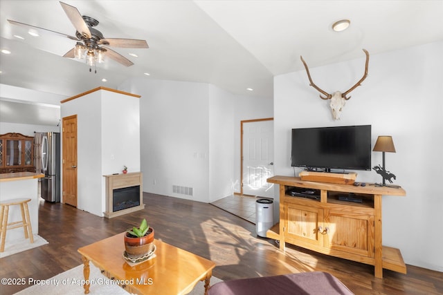 living room with ceiling fan, dark hardwood / wood-style flooring, and lofted ceiling