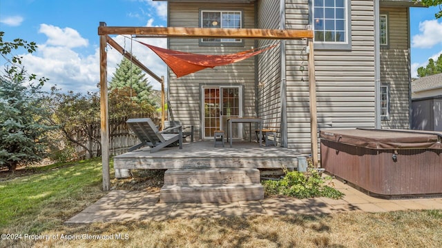 exterior space with a yard, a hot tub, and a wooden deck