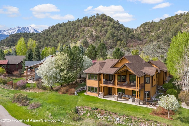 4034 Crystal Bridge Dr, Carbondale, CO 81623 - rear view of property with a patio area, a mountain view, a lawn, an outdoor hangout area, and a view of trees