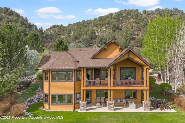 4034 Crystal Bridge Dr, Carbondale, CO 81623 - back of property with an outdoor living space, a patio, a yard, a balcony, and a forest view
