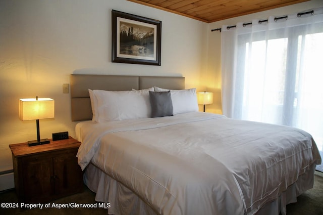 carpeted bedroom featuring wood ceiling