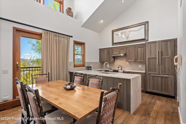 dining room featuring dark hardwood / wood-style floors, sink, and high vaulted ceiling