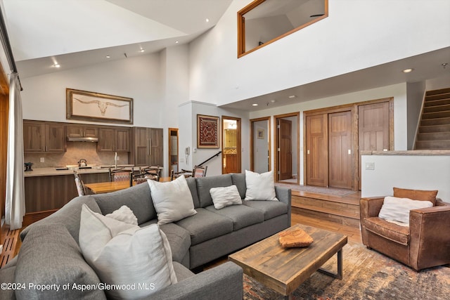 living room featuring light hardwood / wood-style flooring and high vaulted ceiling