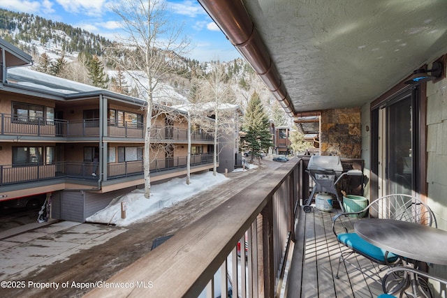 snow covered back of property featuring area for grilling and a mountain view