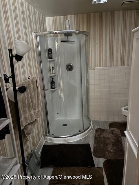 1598 N Yampa Ave, Craig, CO 81625 - bathroom featuring wallpapered walls, a shower stall, and tile walls