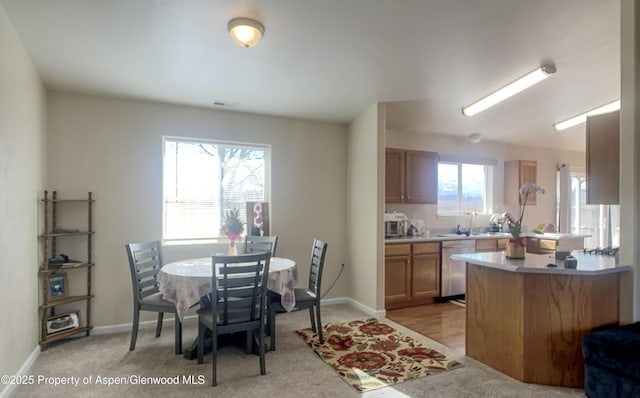 dining space featuring sink and light carpet