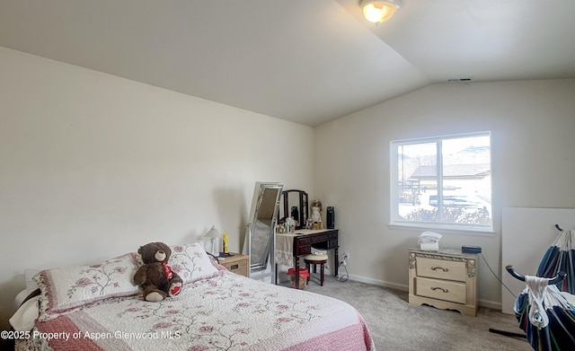 bedroom with lofted ceiling and light colored carpet