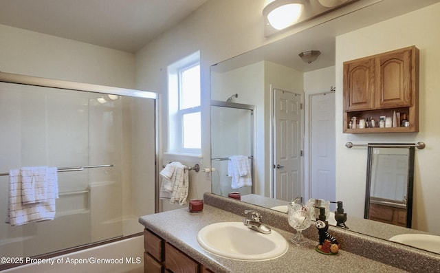 bathroom with vanity and shower / bath combination with glass door