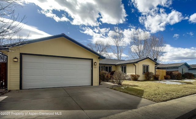 ranch-style home featuring a garage and a front lawn