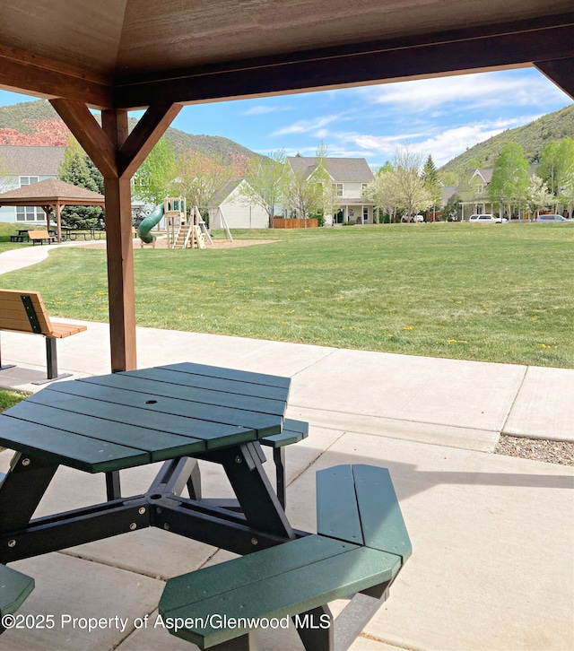 view of patio / terrace with playground community and a mountain view