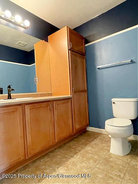 full bath with baseboards, vanity, toilet, and tile patterned floors