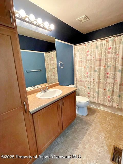 bathroom featuring tile patterned flooring, visible vents, vanity, and toilet