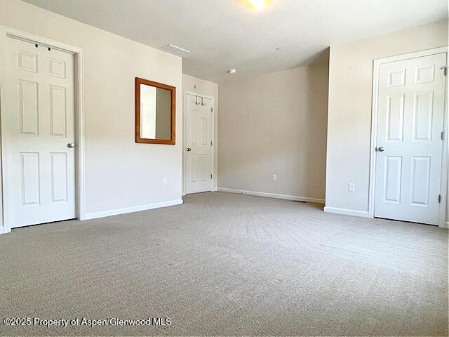 empty room featuring carpet flooring and baseboards