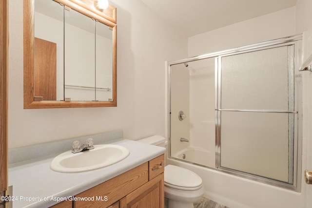 full bathroom featuring shower / bath combination with glass door, vanity, and toilet