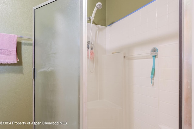 bathroom with a shower with door