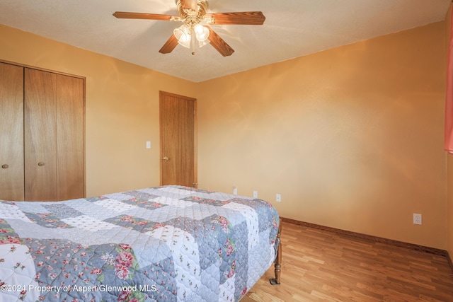 bedroom featuring ceiling fan, wood-type flooring, and a closet