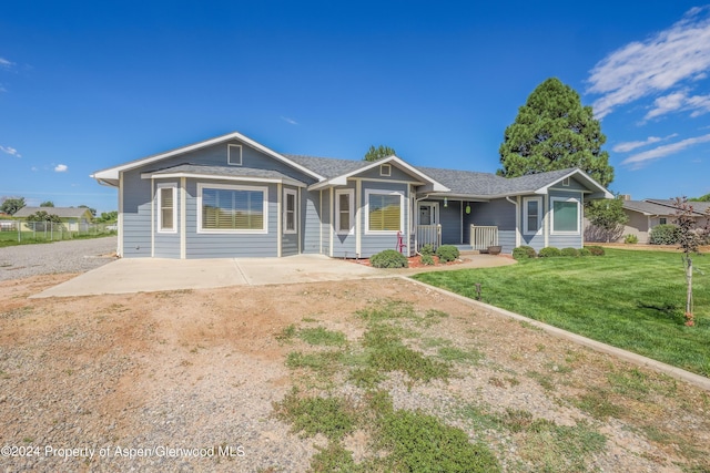 single story home featuring covered porch and a front yard