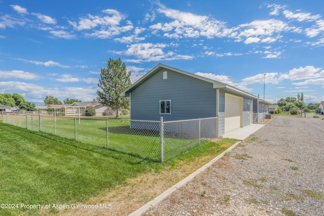 view of property exterior with a lawn and a garage