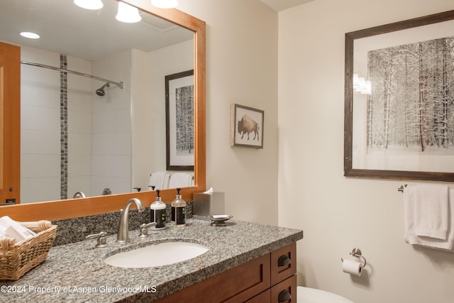 bathroom with vanity and a tile shower