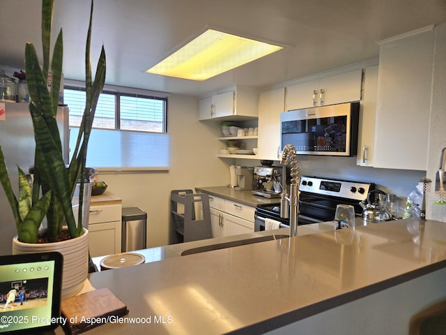 681 S 2nd St Unit G, Carbondale, CO 81623 - kitchen featuring stainless steel appliances, white cabinets, and open shelves