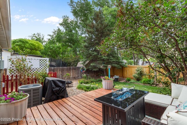 68 E Bonanza Pl, Parachute, CO 81635 - wooden deck with grilling area, a fenced backyard, and a fire pit