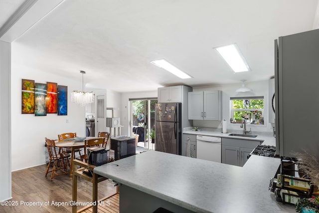 68 E Bonanza Pl, Parachute, CO 81635 - kitchen featuring dishwasher, freestanding refrigerator, light wood-style floors, a peninsula, and plenty of natural light