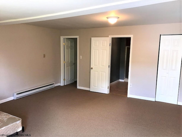 unfurnished bedroom with baseboard heating, dark carpet, and a closet