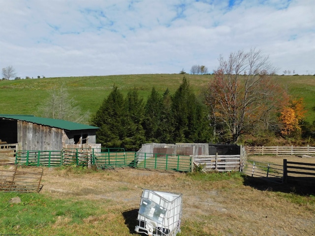 view of stable with a yard and a rural view