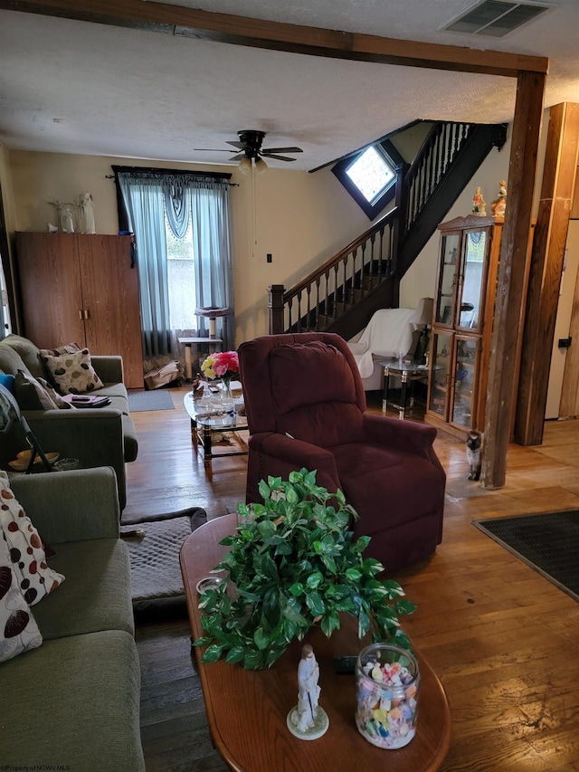 living room with dark hardwood / wood-style flooring and ceiling fan