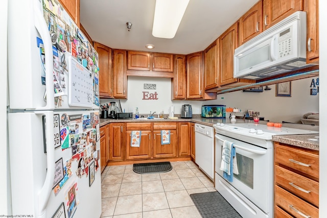 kitchen with light tile floors, white appliances, sink, and light stone counters