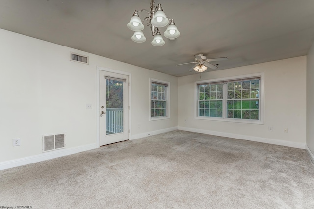 spare room with light carpet and ceiling fan with notable chandelier