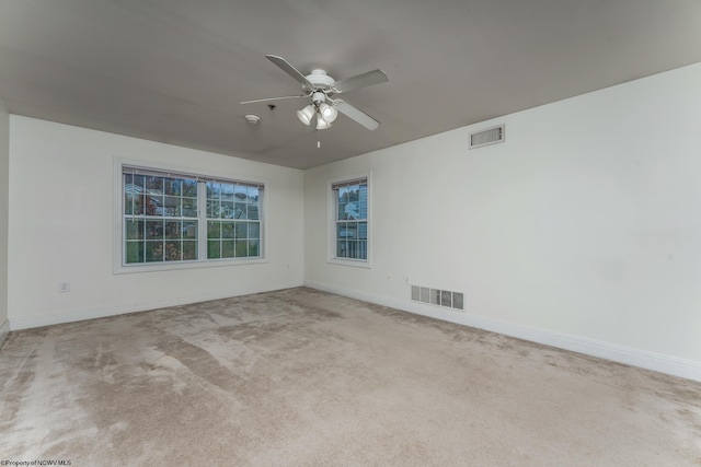 spare room with ceiling fan and light carpet