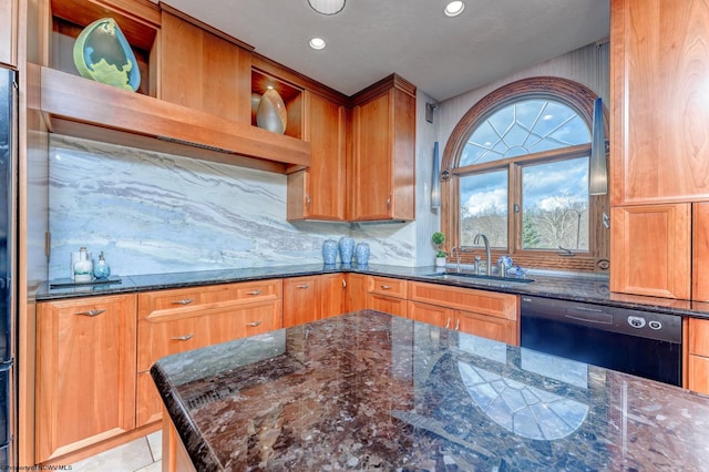 kitchen featuring tasteful backsplash, dark stone countertops, dishwasher, and sink