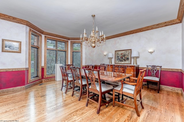 dining space with a chandelier, light hardwood / wood-style flooring, and crown molding