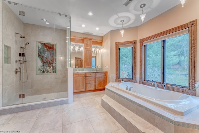 bathroom with tile patterned floors, vanity, and shower with separate bathtub